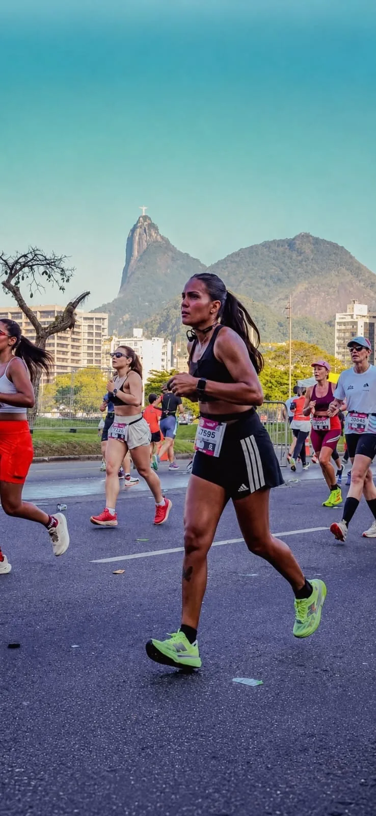 Thais racing on the road in Rio, Christ the Redeemer on the mountain behind her